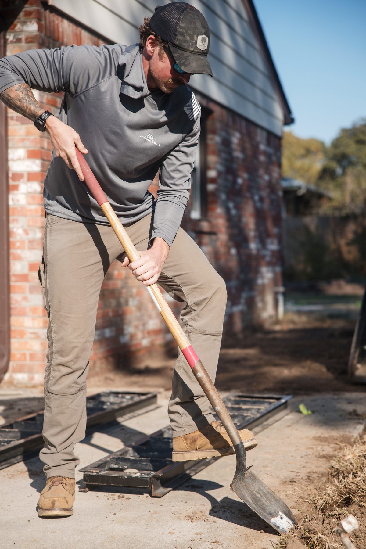 Harrison shoveling along a brick house